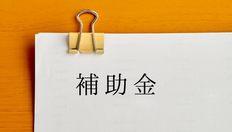 クリップで留めたたくさんの用紙に補助金の文字